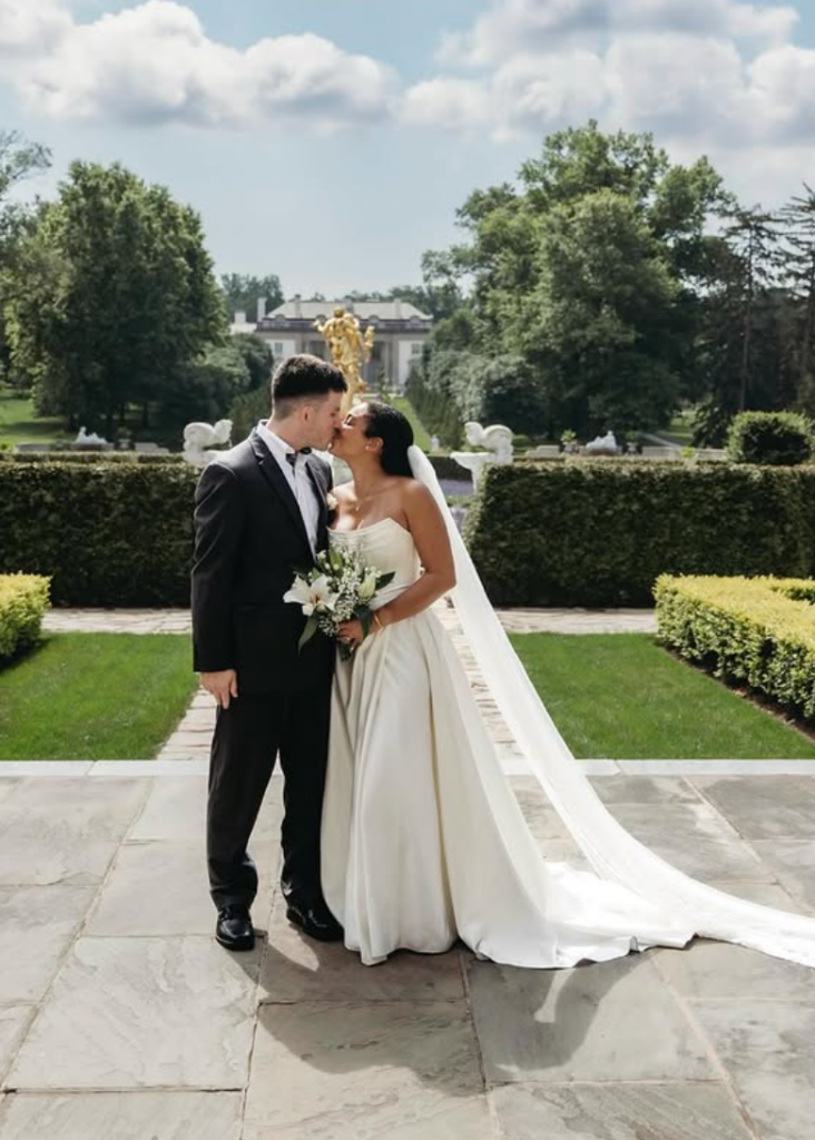 Bride and groom kissing in a garden during their wedding portrait session