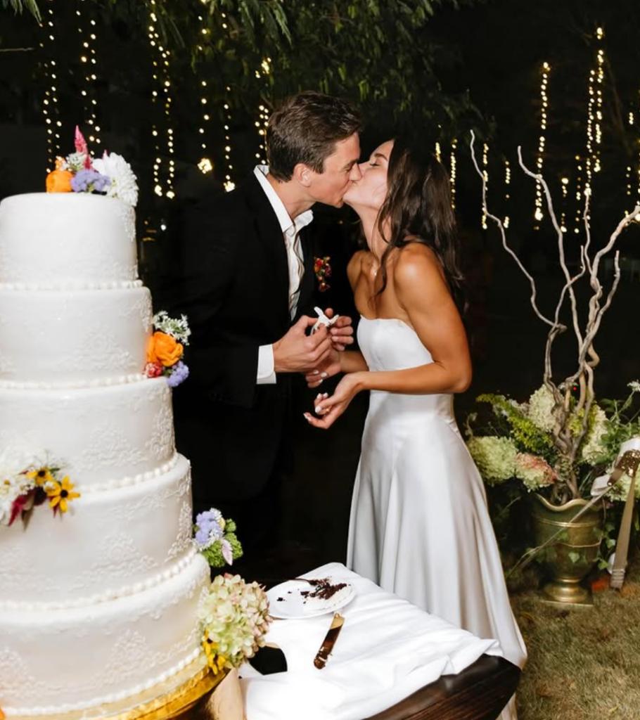 Bride and groom kissing before cutting their wedding cake