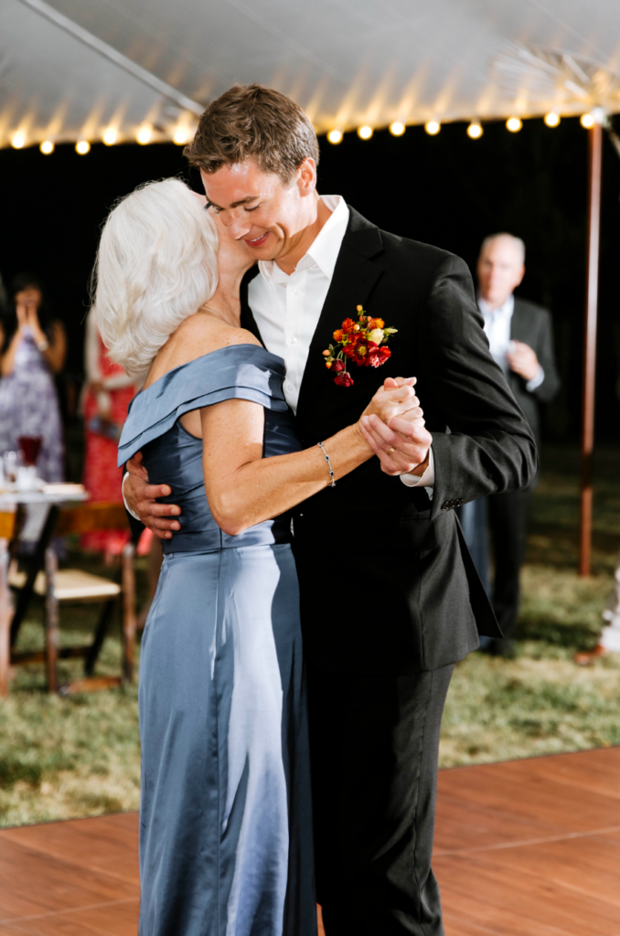 Emotional wedding reception photo of groom dancing with his mother