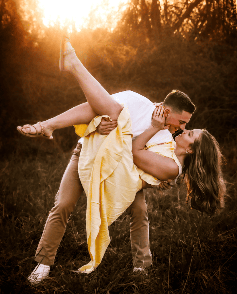Couple dipping in a fall field during an engagement photography session