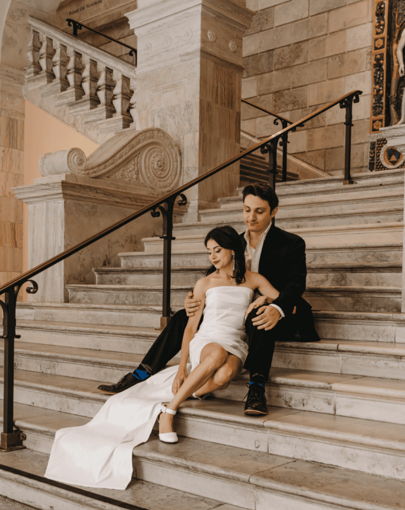 couple sits on stairs for a wedding portrait