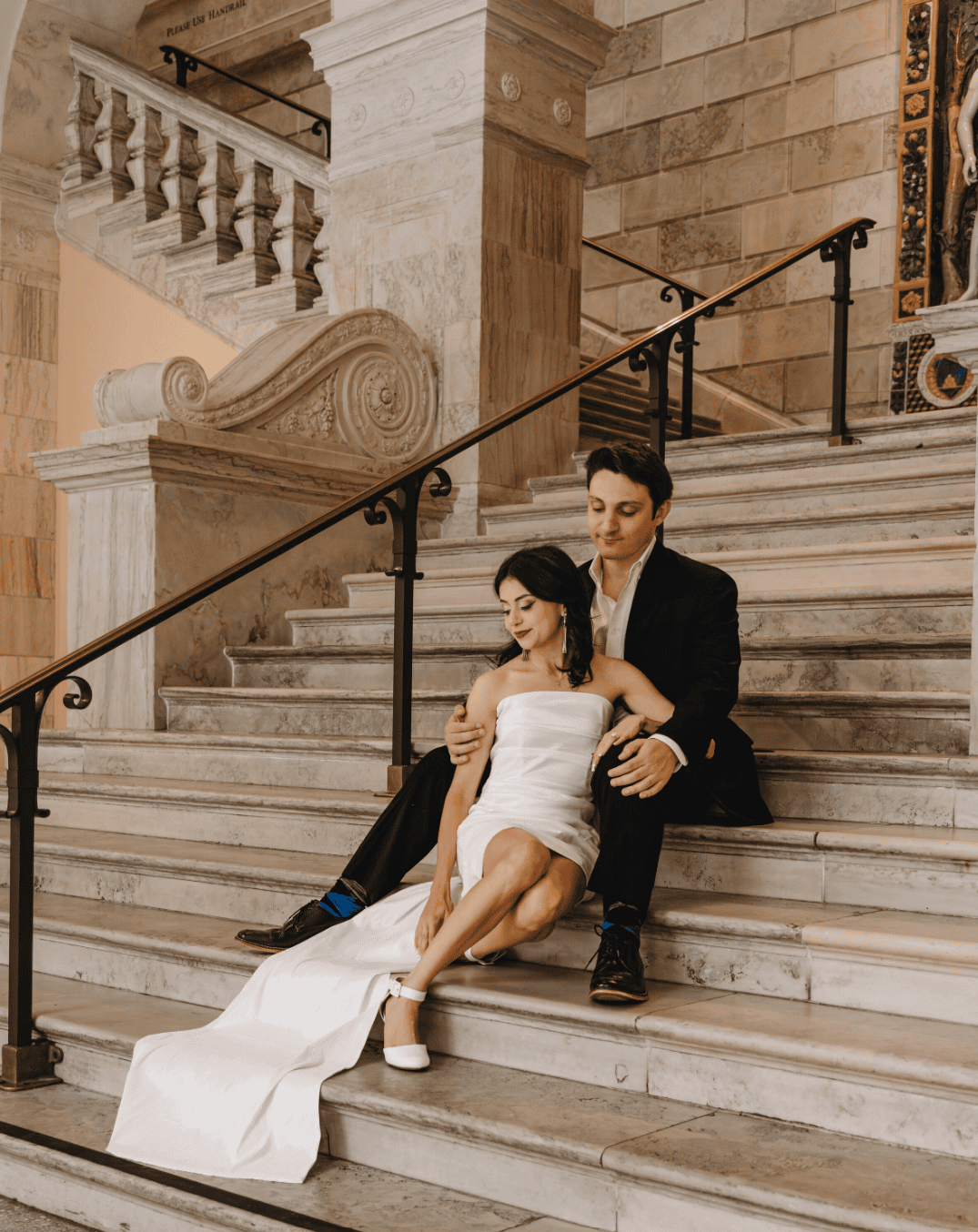 couple sits on stairs for a wedding portrait