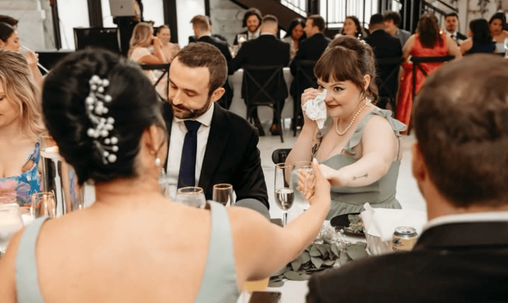 Wedding guests tearing up during wedding reception.