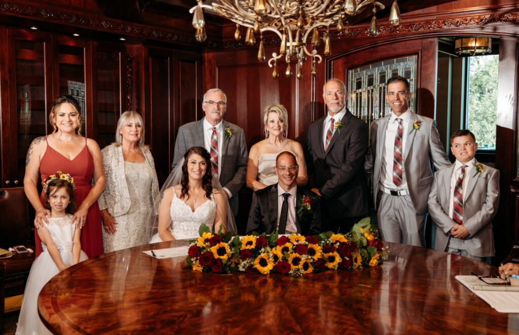 couple signing marriage license surrounded by family